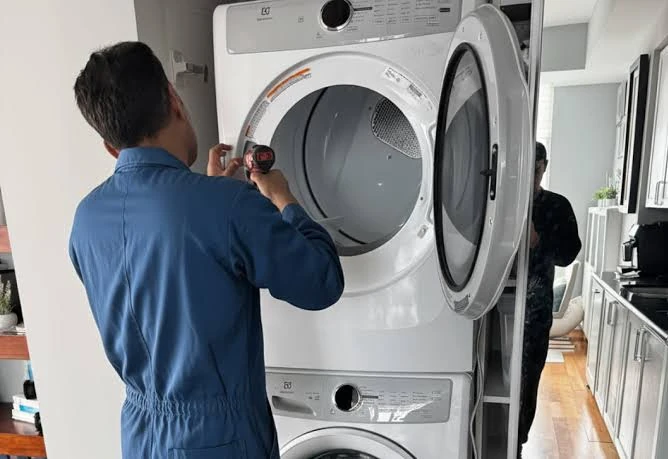 Technician inspecting the drum of a front-loading laundry appliance