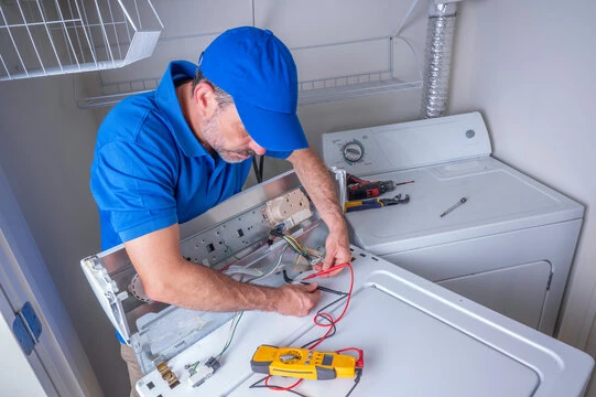 Technician testing the electrical components of a top-loading washing machine